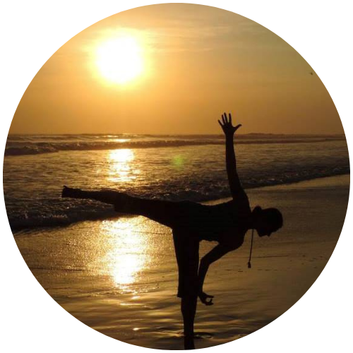 Katherine Sauer doing a yoga pose on a beach at sunset