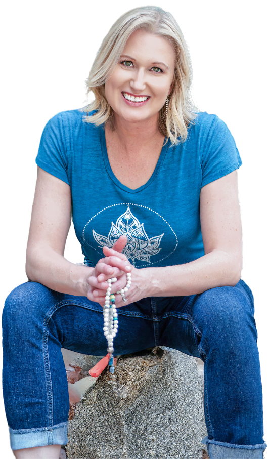 Katherine Sauer, a smiling blonde woman, wearing a teal tee and holding mala beads